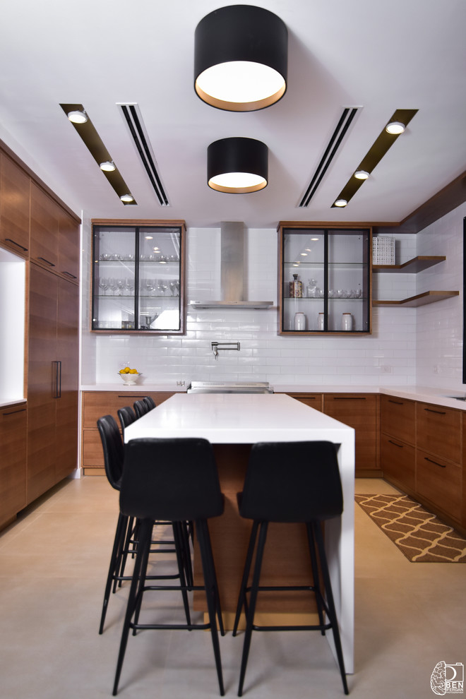 Example of a mid-sized trendy u-shaped porcelain tile and beige floor kitchen design in Los Angeles with an undermount sink, flat-panel cabinets, medium tone wood cabinets, quartz countertops, white backsplash, subway tile backsplash, stainless steel appliances, an island and white countertops