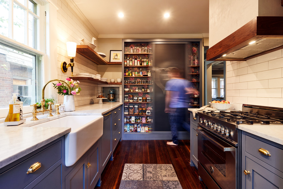 Design ideas for a classic galley kitchen in Atlanta with a belfast sink, shaker cabinets, blue cabinets, white splashback, metro tiled splashback, stainless steel appliances, no island, marble worktops and dark hardwood flooring.