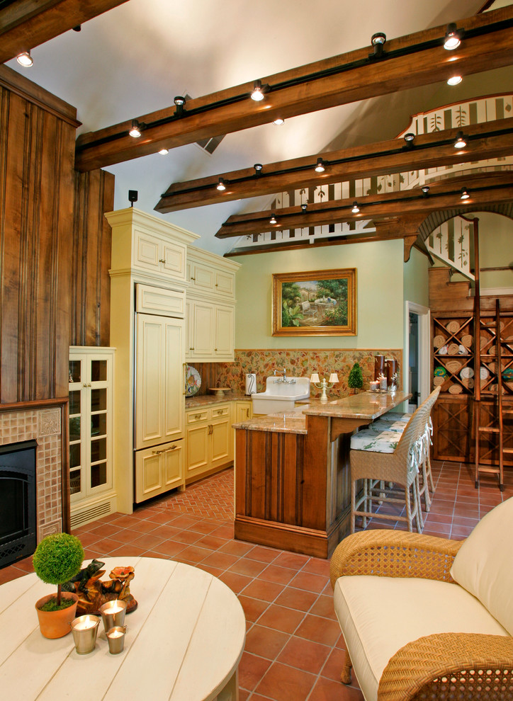 Klassisk inredning av ett litet kök, med en rustik diskho, granitbänkskiva, flerfärgad stänkskydd, integrerade vitvaror och klinkergolv i terrakotta