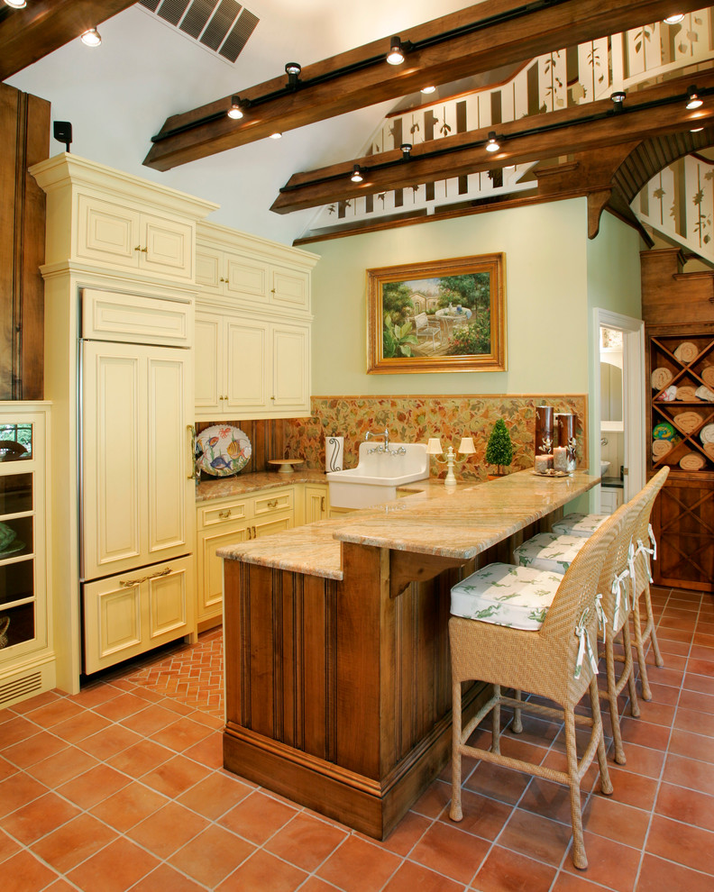 Bild på ett litet vintage kök, med en rustik diskho, luckor med upphöjd panel, granitbänkskiva, flerfärgad stänkskydd, integrerade vitvaror, klinkergolv i terrakotta och gula skåp