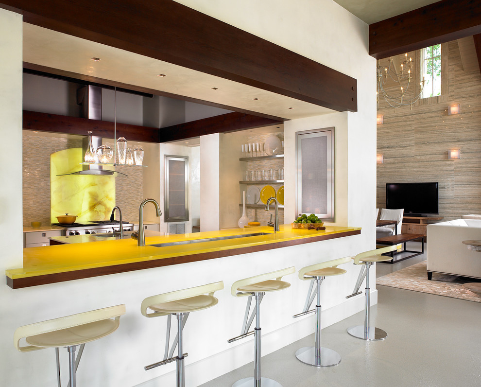 Trendy u-shaped kitchen photo in Nashville with yellow backsplash, stone slab backsplash, stainless steel appliances, glass-front cabinets, stainless steel cabinets and yellow countertops
