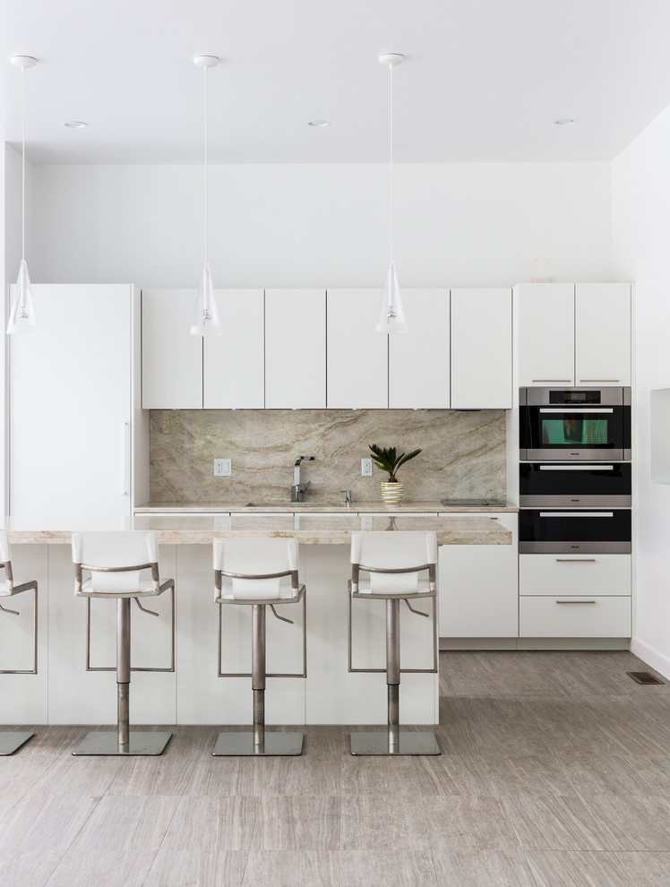 Bild på ett funkis kök, med släta luckor, vita skåp, ljust trägolv, en köksö och stänkskydd i marmor