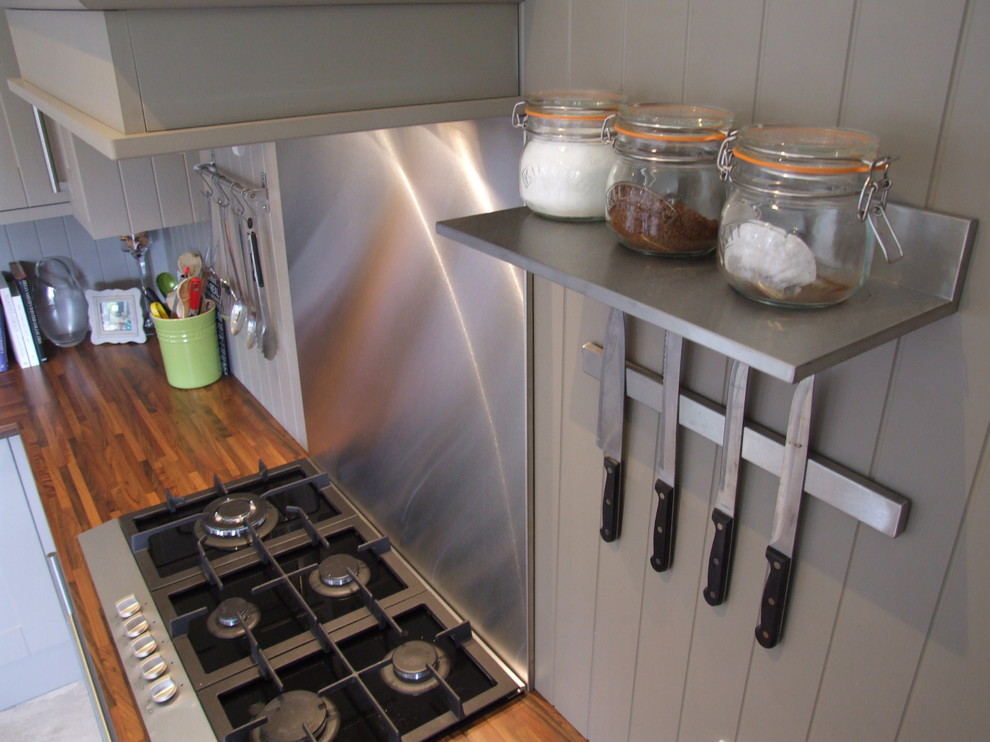 Bild på ett mellanstort shabby chic-inspirerat kök, med en nedsänkt diskho, skåp i shakerstil, grå skåp, laminatbänkskiva, grått stänkskydd, svarta vitvaror, klinkergolv i keramik och en köksö