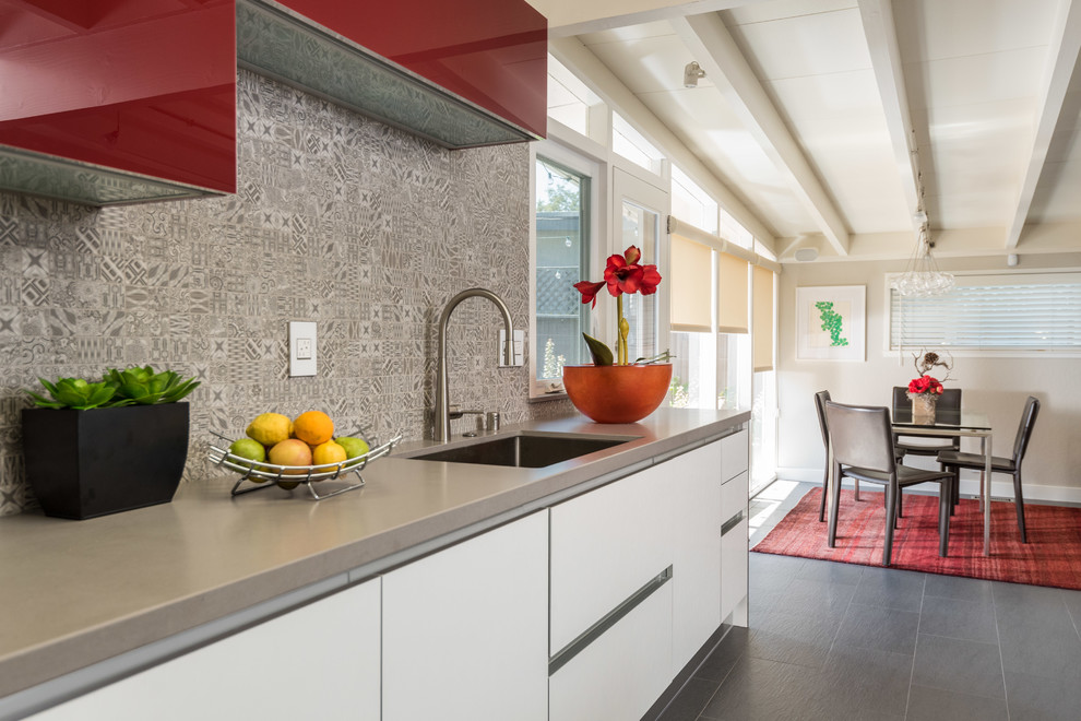 Example of a mid-sized trendy u-shaped porcelain tile and gray floor eat-in kitchen design in San Francisco with an undermount sink, flat-panel cabinets, white cabinets, quartz countertops, multicolored backsplash, ceramic backsplash, stainless steel appliances, an island and gray countertops