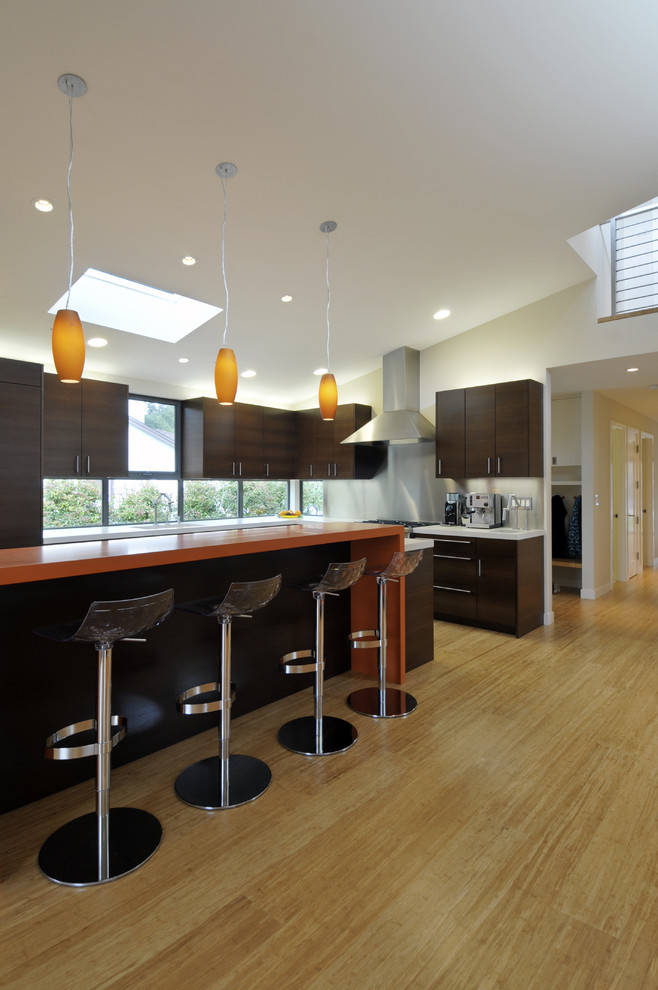 Immagine di una cucina design con ante lisce e ante in legno bruno