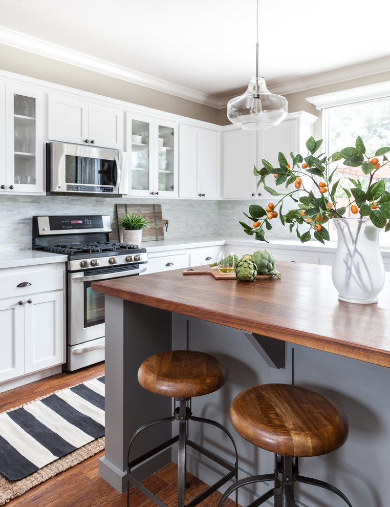 Example of a mid-sized country u-shaped medium tone wood floor eat-in kitchen design in Sacramento with an undermount sink, shaker cabinets, gray cabinets, quartzite countertops, gray backsplash, stone tile backsplash, stainless steel appliances and an island