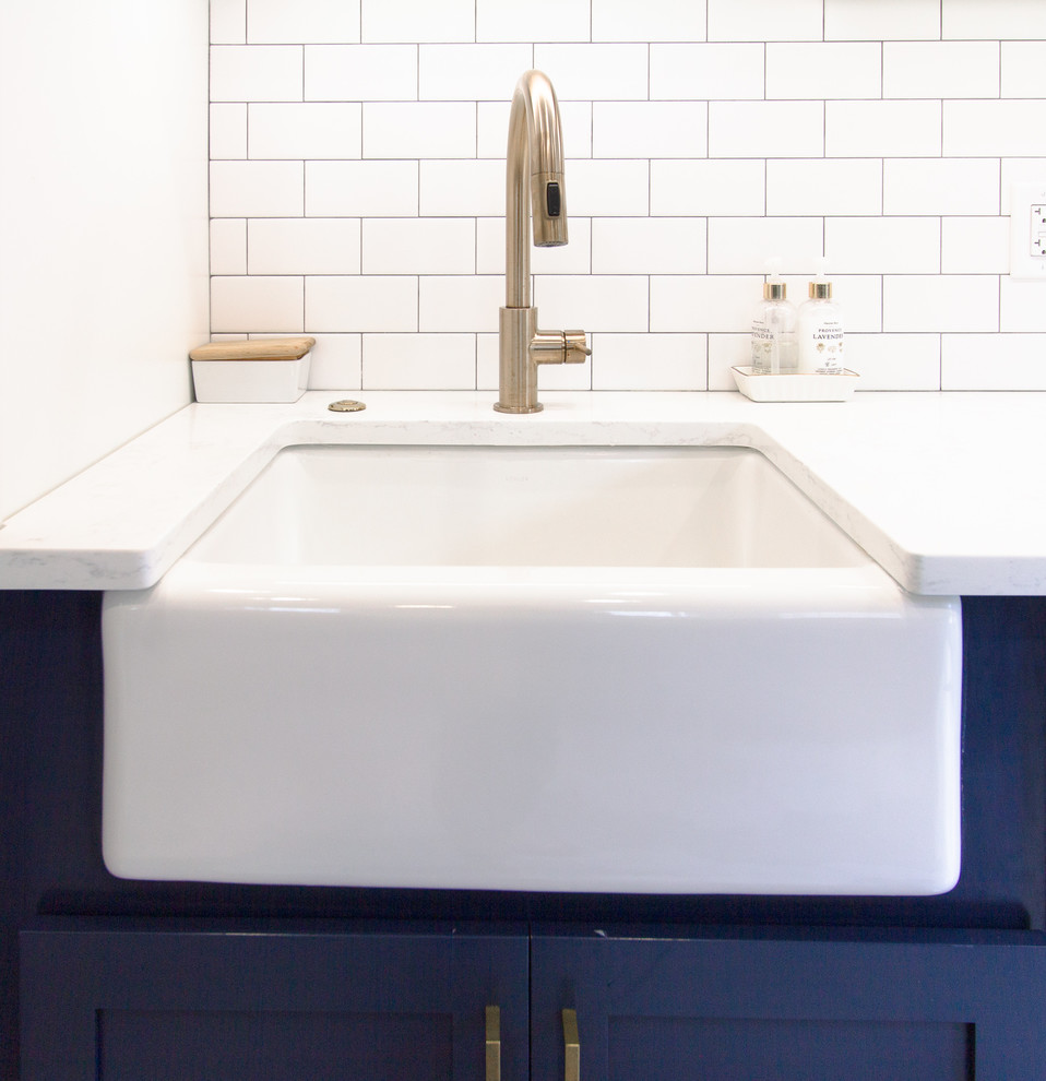 Example of a mid-sized minimalist galley porcelain tile and multicolored floor eat-in kitchen design in Philadelphia with a farmhouse sink, recessed-panel cabinets, marble countertops, white backsplash, subway tile backsplash, stainless steel appliances, no island, multicolored countertops and blue cabinets