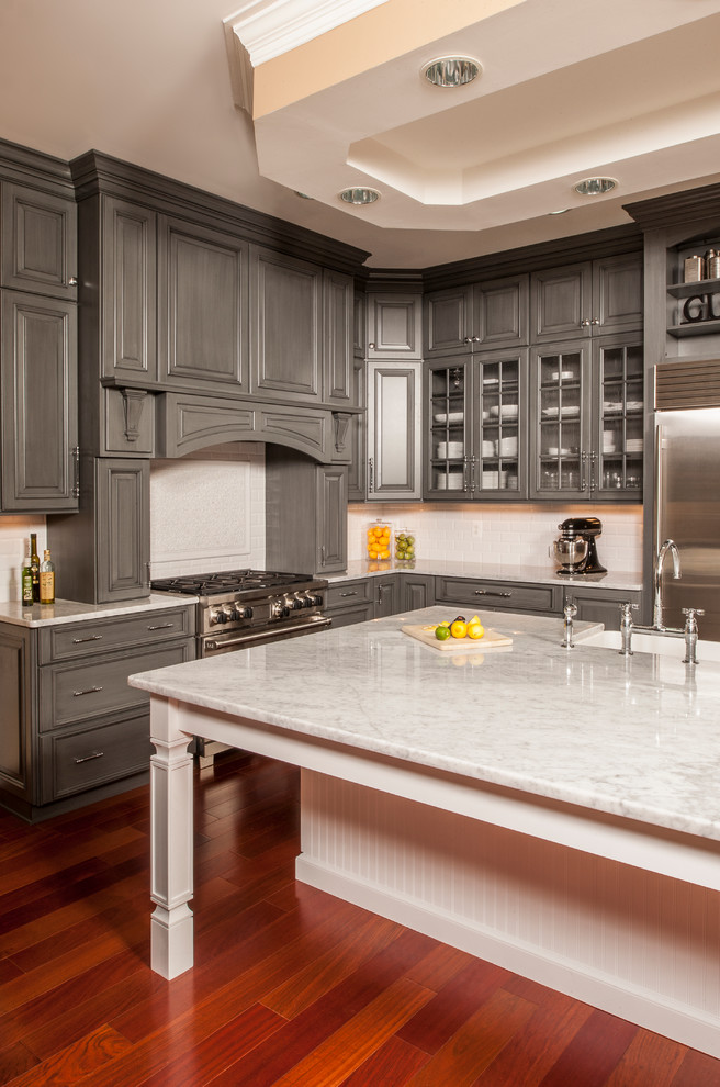 Inspiration for a traditional kitchen in DC Metro with a belfast sink, raised-panel cabinets, grey cabinets, white splashback, metro tiled splashback, stainless steel appliances and dark hardwood flooring.