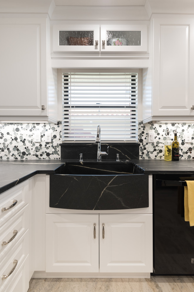 タンパにあるトランジショナルスタイルのおしゃれなキッチン (シングルシンク、レイズドパネル扉のキャビネット、白いキャビネット、ソープストーンカウンター、白いキッチンパネル、ガラスタイルのキッチンパネル、黒い調理設備) の写真