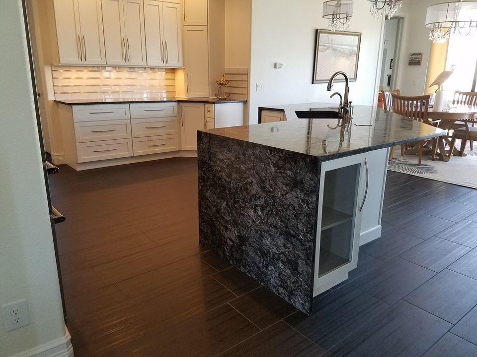 Medium sized classic u-shaped open plan kitchen in Miami with a submerged sink, shaker cabinets, stainless steel cabinets, granite worktops, stainless steel appliances, dark hardwood flooring, an island and brown floors.
