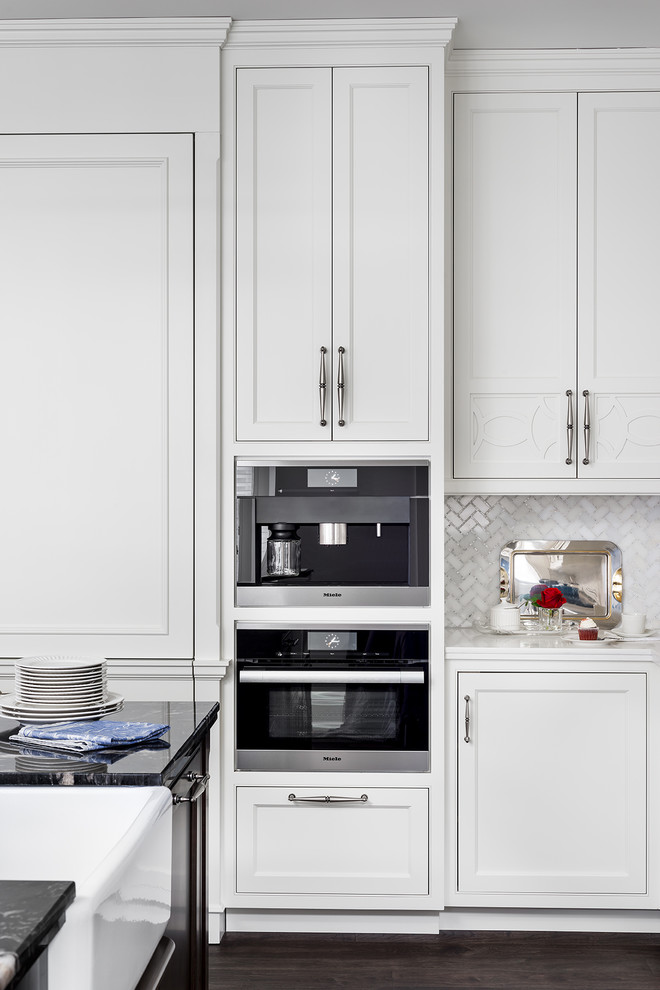 Inspiration for a large classic l-shaped kitchen/diner in Toronto with a belfast sink, white cabinets, granite worktops, stainless steel appliances, dark hardwood flooring, an island, shaker cabinets, white splashback and mosaic tiled splashback.