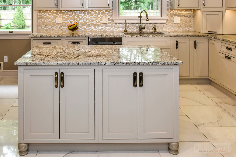 Large u-shaped eat-in kitchen photo in New York with an undermount sink, shaker cabinets, white cabinets, granite countertops, beige backsplash, stainless steel appliances and an island