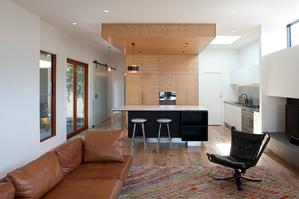 Offene, Zweizeilige Moderne Küche mit flächenbündigen Schrankfronten, hellbraunen Holzschränken, braunem Holzboden und Kücheninsel in Melbourne
