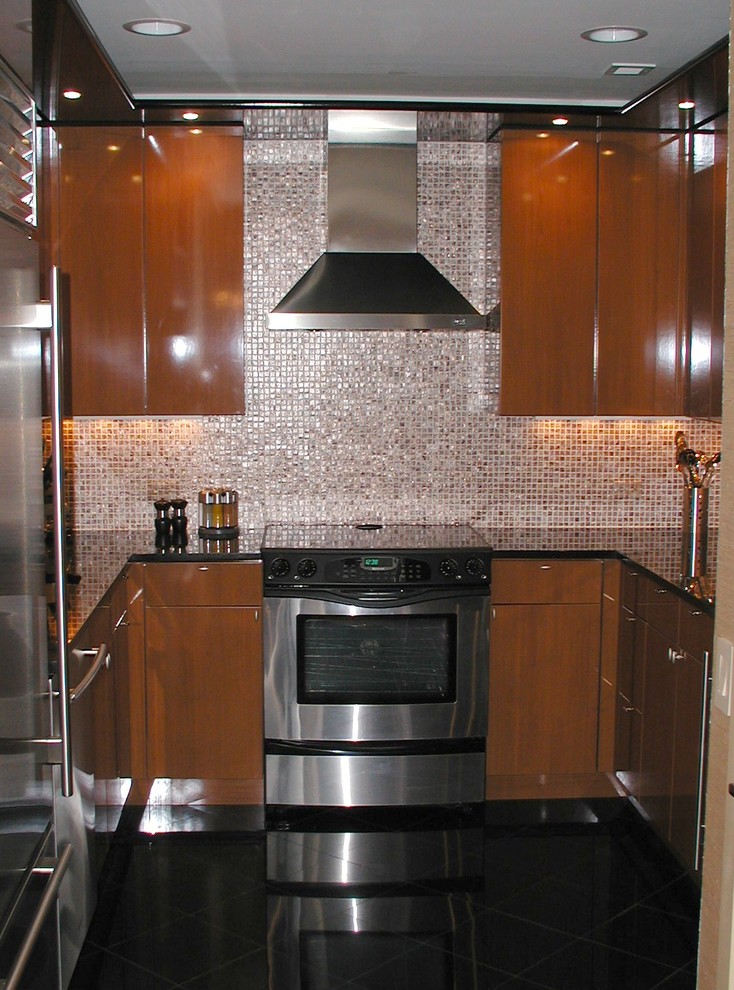 Bild på ett mellanstort funkis u-kök, med en undermonterad diskho, släta luckor, skåp i mellenmörkt trä, granitbänkskiva, orange stänkskydd och rostfria vitvaror