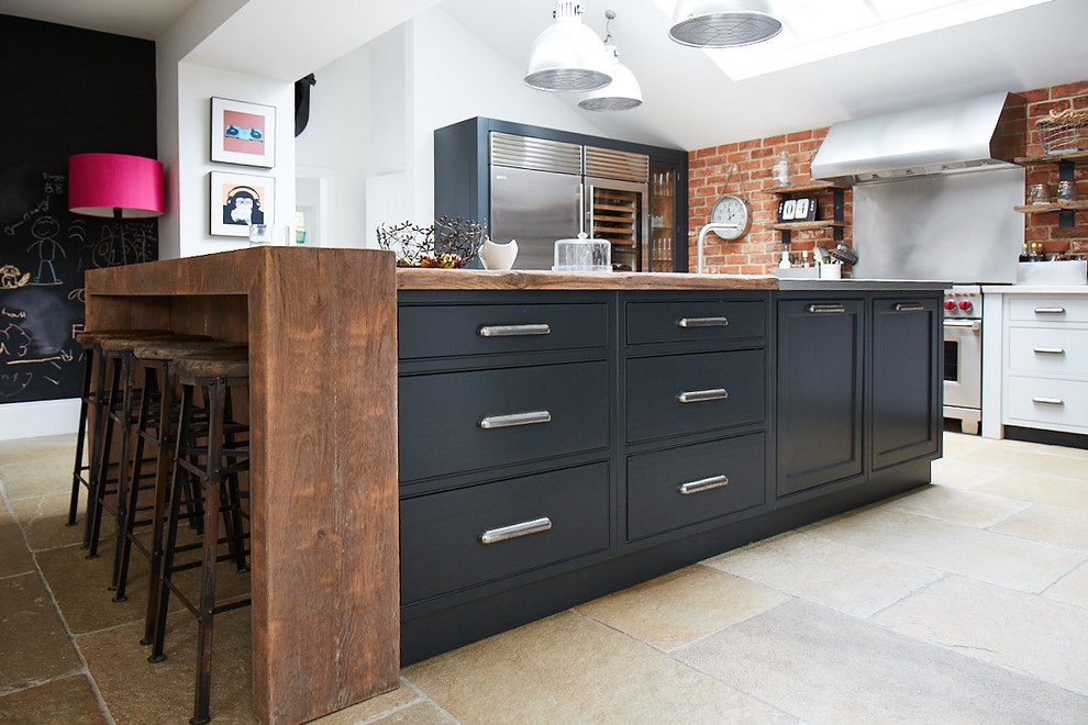 Large rustic kitchen/diner in Other with an integrated sink, beaded cabinets, blue cabinets, stainless steel worktops, stainless steel appliances, ceramic flooring, an island, beige floors and grey worktops.