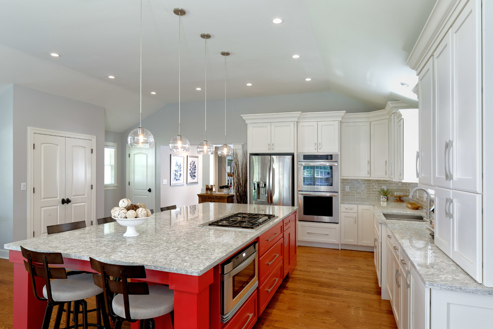 Imagen de cocinas en L clásica con armarios estilo shaker, encimera de cuarzo compacto, salpicadero verde, salpicadero de azulejos tipo metro, electrodomésticos de acero inoxidable, suelo de madera en tonos medios, una isla, fregadero de doble seno y puertas de armario blancas
