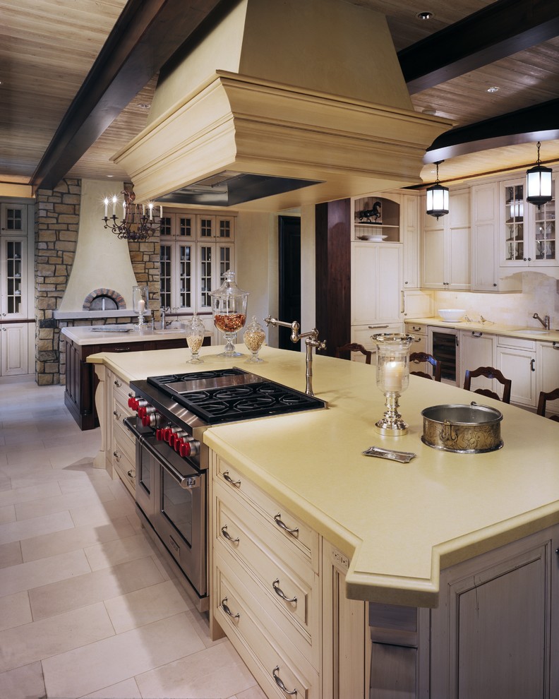 Diseño de cocina tradicional con armarios con paneles con relieve, puertas de armario blancas y electrodomésticos de acero inoxidable