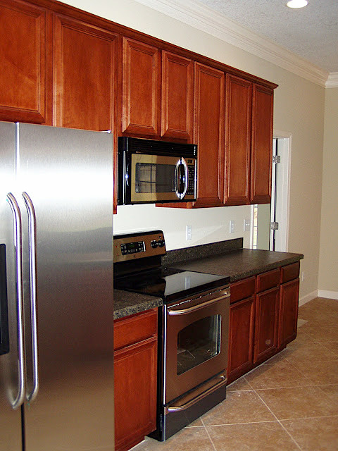 Example of a mid-sized classic single-wall kitchen design in Jacksonville with recessed-panel cabinets, medium tone wood cabinets, granite countertops, stainless steel appliances, a peninsula and gray countertops