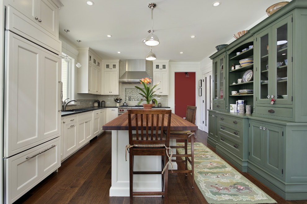 Large elegant l-shaped dark wood floor and brown floor eat-in kitchen photo in Omaha with recessed-panel cabinets, white cabinets, wood countertops, beige backsplash, paneled appliances, an undermount sink, porcelain backsplash and an island