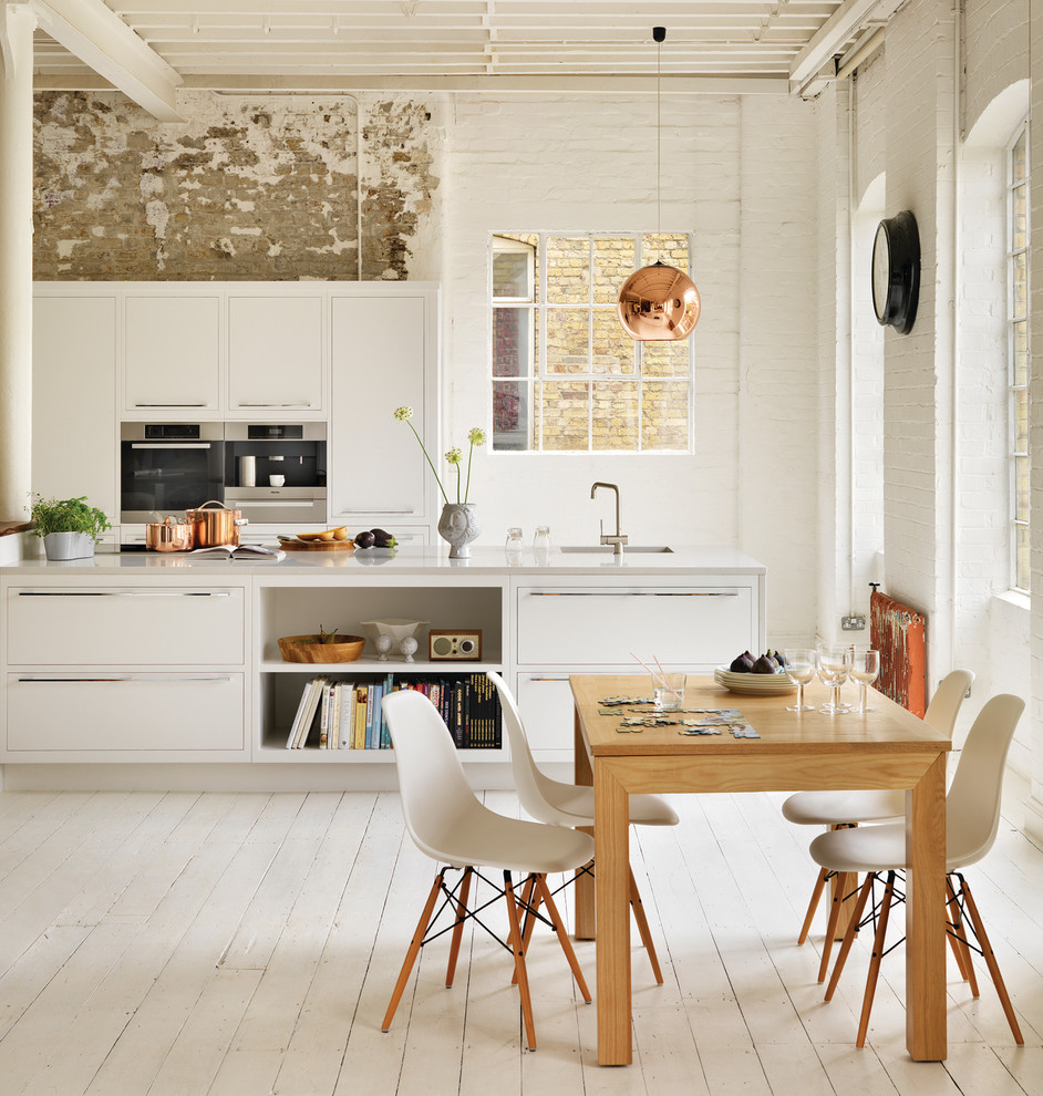 Exempel på ett modernt kök och matrum, med en köksö, målat trägolv, en undermonterad diskho, släta luckor, vita skåp, bänkskiva i kvarts och rostfria vitvaror