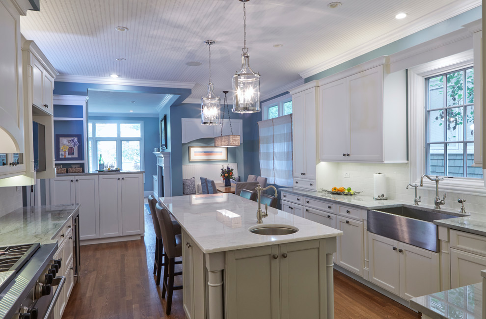 Photo of a large nautical u-shaped kitchen/diner in Chicago with recessed-panel cabinets, white cabinets and an island.