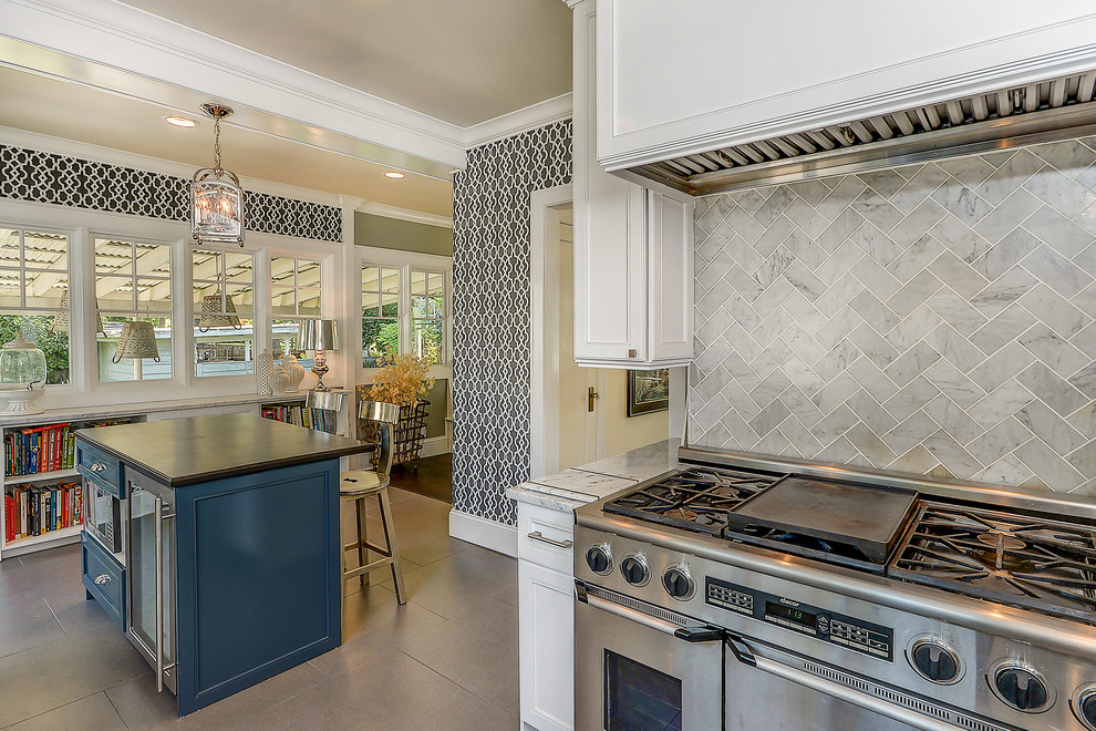 This is an example of a large traditional galley kitchen/diner in Santa Barbara with a submerged sink, recessed-panel cabinets, white cabinets, quartz worktops, grey splashback, stone tiled splashback, stainless steel appliances, porcelain flooring, an island, brown floors and grey worktops.