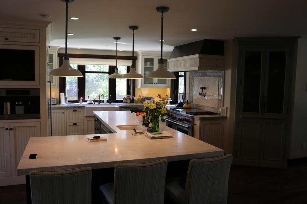 Inspiration for a mid-sized farmhouse dark wood floor eat-in kitchen remodel in Other with recessed-panel cabinets, white cabinets, granite countertops, gray backsplash, stone slab backsplash, stainless steel appliances and an island