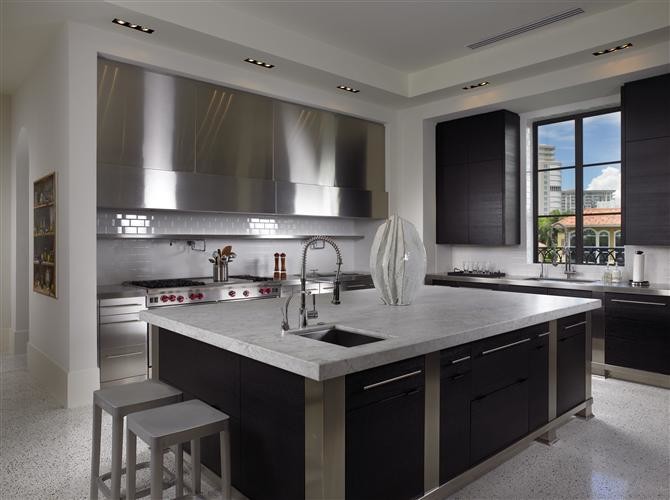 Inspiration for a large contemporary enclosed kitchen in Miami with a submerged sink, flat-panel cabinets, dark wood cabinets, marble worktops, white splashback, metro tiled splashback, stainless steel appliances, terrazzo flooring and an island.