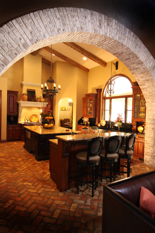 Exempel på ett mellanstort medelhavsstil kök med öppen planlösning, med en rustik diskho, luckor med glaspanel, skåp i mellenmörkt trä, granitbänkskiva, svart stänkskydd, stänkskydd i sten, rostfria vitvaror, tegelgolv och flera köksöar