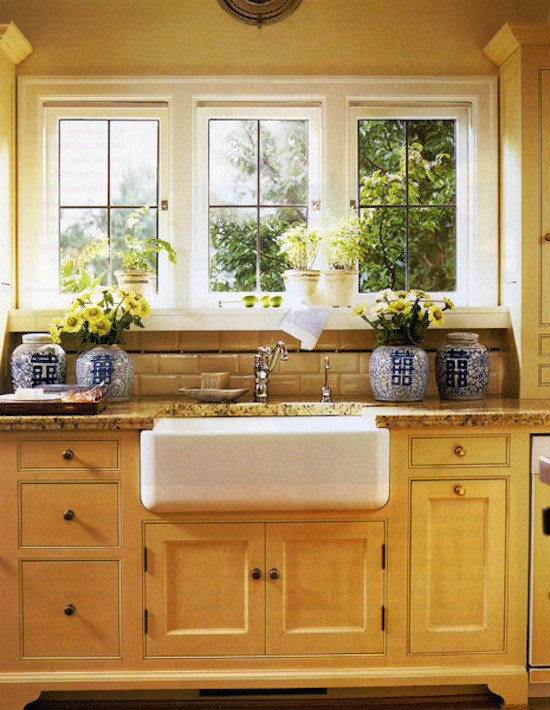 Klassisk inredning av ett mellanstort kök, med en rustik diskho, luckor med infälld panel, skåp i ljust trä, granitbänkskiva, beige stänkskydd, stänkskydd i porslinskakel, rostfria vitvaror och ljust trägolv