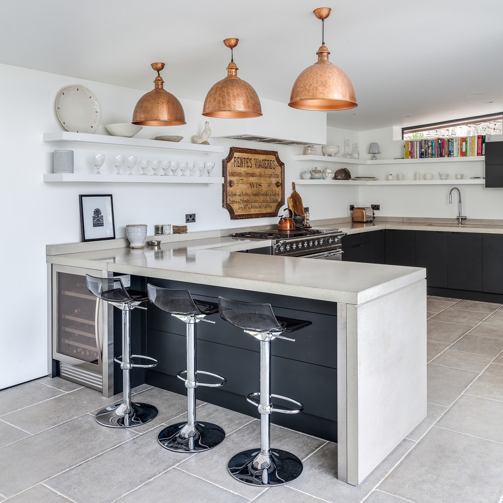 Klassische Küche in U-Form mit flächenbündigen Schrankfronten, schwarzen Schränken, Küchengeräten aus Edelstahl und Halbinsel in London