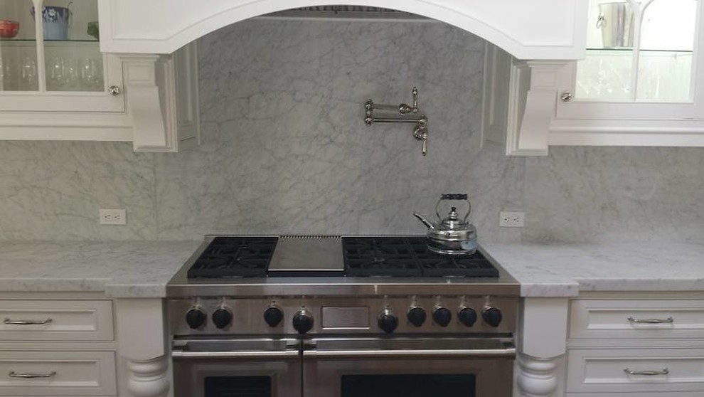 Foto di una cucina chic con ante bianche, top in marmo, paraspruzzi bianco, paraspruzzi in lastra di pietra e elettrodomestici in acciaio inossidabile