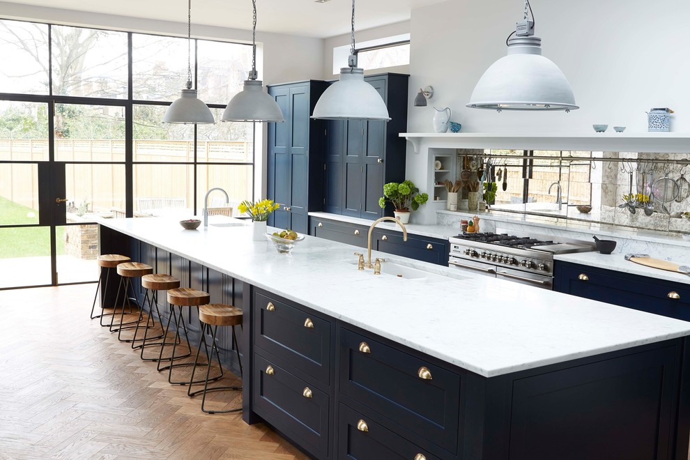 Design ideas for a traditional galley kitchen in Other with a submerged sink, shaker cabinets, blue cabinets, grey splashback, integrated appliances, medium hardwood flooring, an island and brown floors.