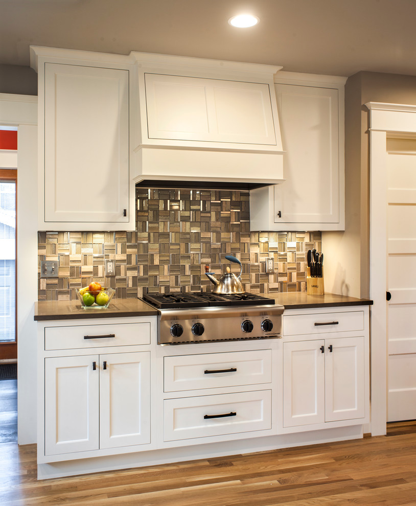 Example of a mid-sized arts and crafts u-shaped light wood floor open concept kitchen design in Portland with an undermount sink, shaker cabinets, white cabinets, quartz countertops, gray backsplash, mosaic tile backsplash, stainless steel appliances and a peninsula