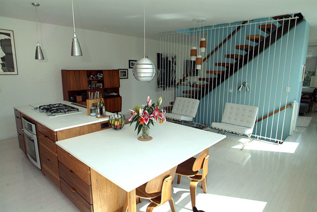 Bild på ett litet funkis kök och matrum, med skåp i mellenmörkt trä, bänkskiva i koppar, rostfria vitvaror, ljust trägolv och en köksö