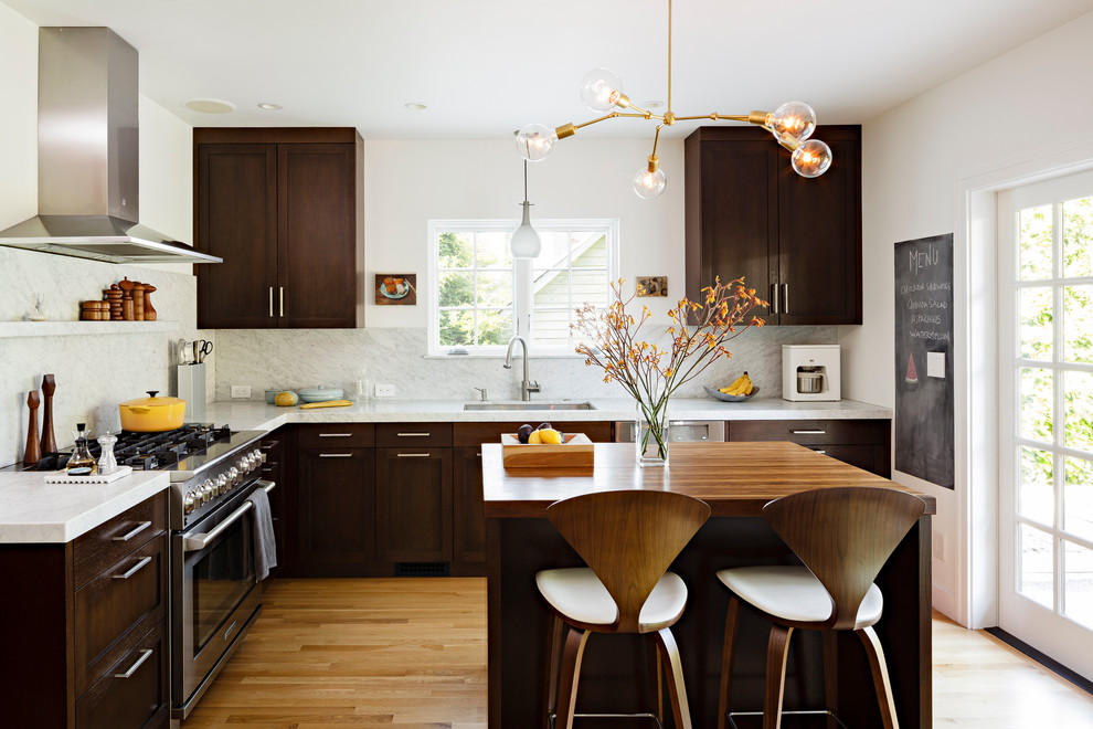 Kitchen - mid-sized contemporary l-shaped medium tone wood floor kitchen idea in Portland with wood countertops, stainless steel appliances, shaker cabinets, dark wood cabinets, white backsplash, stone slab backsplash and an undermount sink