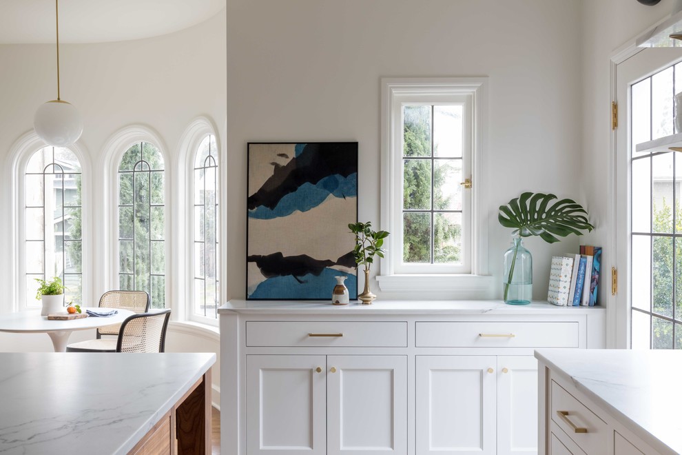 Esempio di una cucina eclettica di medie dimensioni con lavello stile country, ante in stile shaker, ante bianche, top in marmo, paraspruzzi bianco, parquet chiaro e pavimento marrone