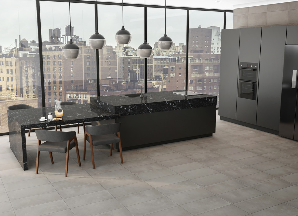Cette image montre une cuisine américaine minimaliste avec plan de travail carrelé, un sol en carrelage de céramique, îlot, un sol gris et plan de travail noir.