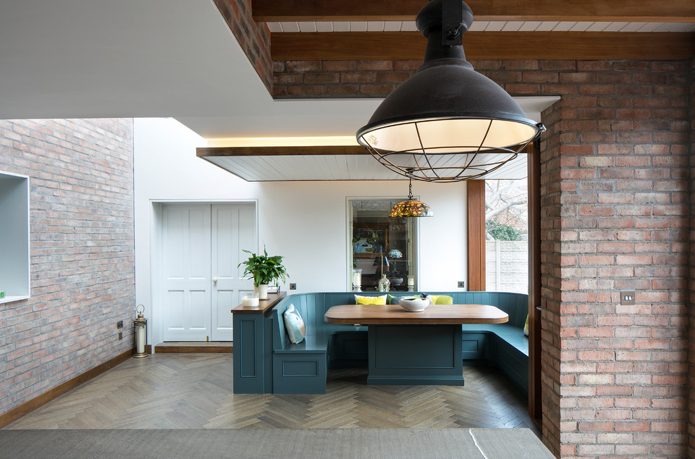 Industriell inredning av ett mellanstort grå grått kök och matrum, med en rustik diskho, skåp i shakerstil, blå skåp, bänkskiva i kvarts, svarta vitvaror, mörkt trägolv och en köksö