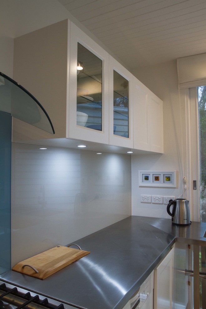 Esempio di una cucina classica di medie dimensioni con ante in stile shaker, top in acciaio inossidabile, paraspruzzi blu, paraspruzzi con lastra di vetro, parquet chiaro e nessuna isola