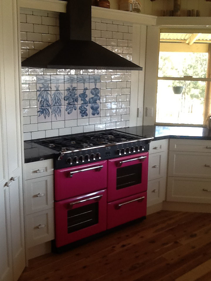 Klassische Küche mit Küchenrückwand in Weiß, Rückwand aus Keramikfliesen, bunten Elektrogeräten und braunem Holzboden in Sydney
