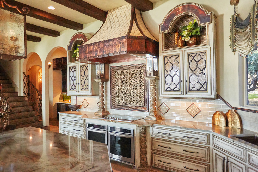 Inspiration for a huge mediterranean galley ceramic tile eat-in kitchen remodel in Dallas with an undermount sink, raised-panel cabinets, beige cabinets, granite countertops, beige backsplash, ceramic backsplash, stainless steel appliances and an island