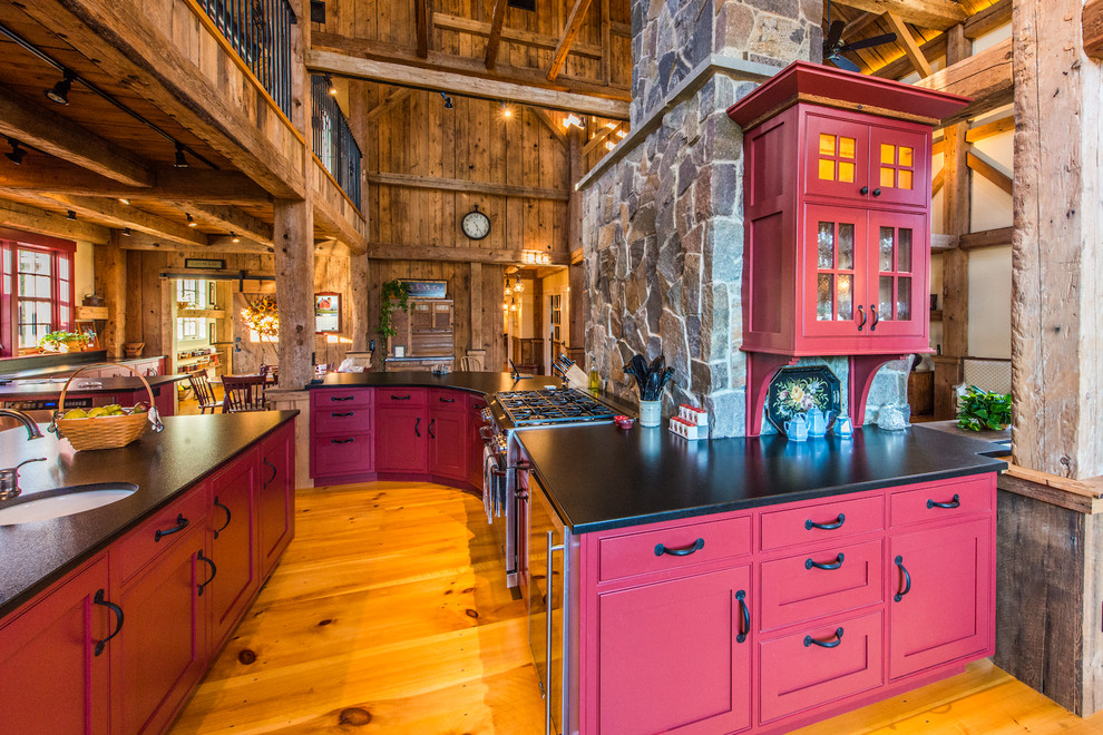 Rustik inredning av ett mycket stort kök, med luckor med infälld panel, röda skåp, granitbänkskiva, rostfria vitvaror, ljust trägolv och en köksö