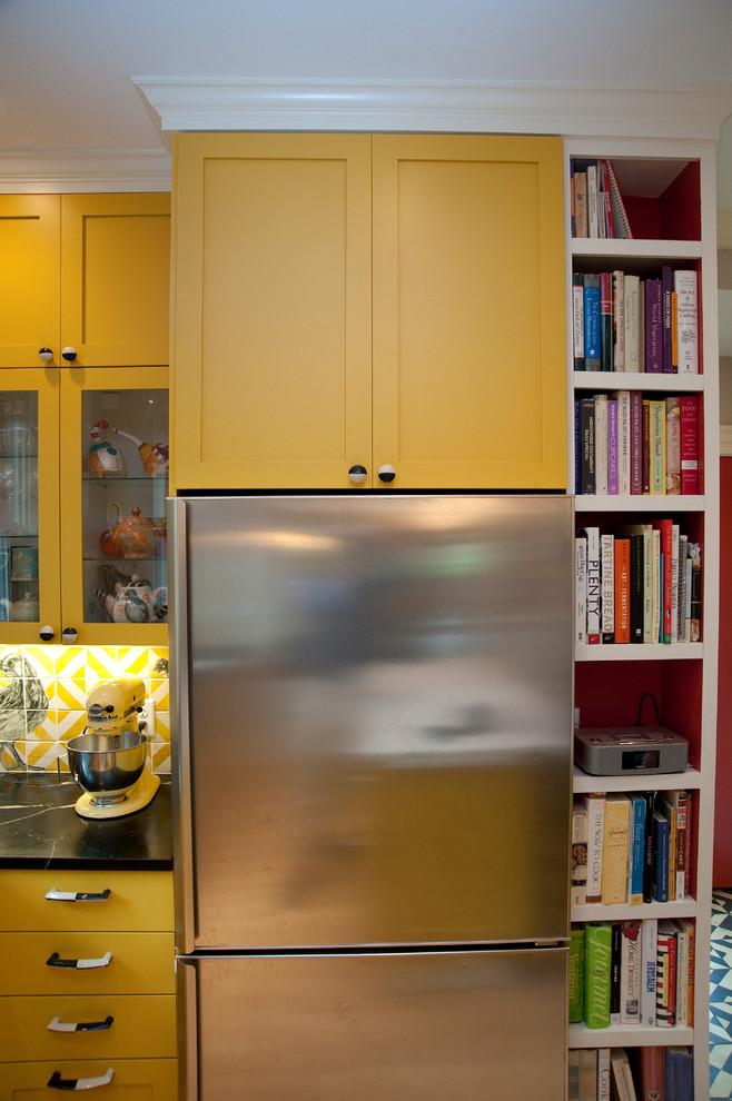 Mid-sized eclectic l-shaped enclosed kitchen photo in Boston with an undermount sink, soapstone countertops, yellow cabinets, shaker cabinets and stainless steel appliances