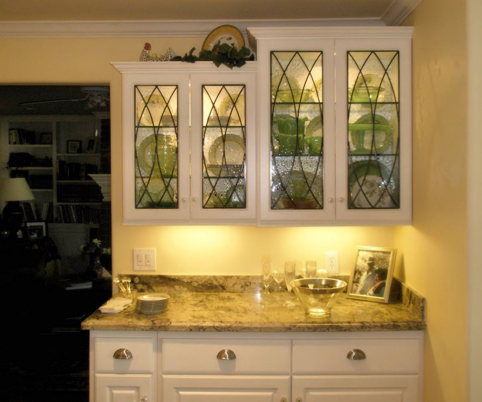 Modelo de cocina de estilo americano con armarios tipo vitrina, puertas de armario blancas, encimera de granito y salpicadero beige