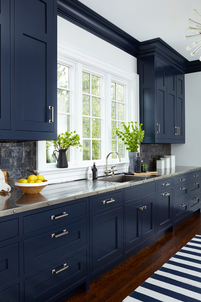 Exempel på ett mellanstort modernt linjärt kök, med en undermonterad diskho, skåp i shakerstil, blå skåp, bänkskiva i rostfritt stål, svart stänkskydd, mörkt trägolv och brunt golv