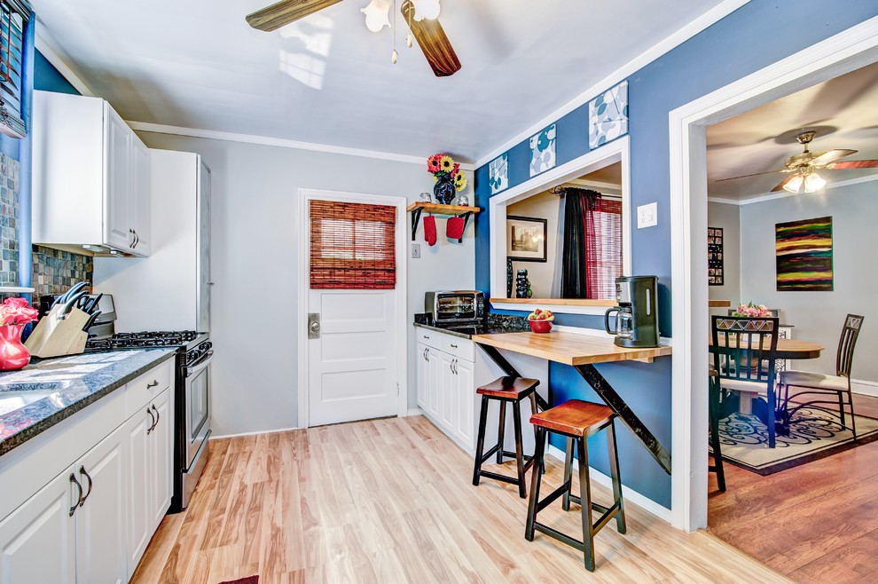 フィラデルフィアにある低価格の小さなトランジショナルスタイルのおしゃれなキッチン (アンダーカウンターシンク、白いキャビネット、御影石カウンター、マルチカラーのキッチンパネル、シルバーの調理設備、ラミネートの床) の写真