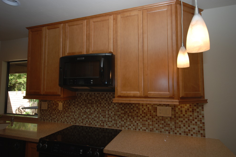 Foto di una cucina parallela chic chiusa con lavello sottopiano, ante lisce, ante in legno scuro, top in quarzo composito, paraspruzzi marrone e elettrodomestici neri