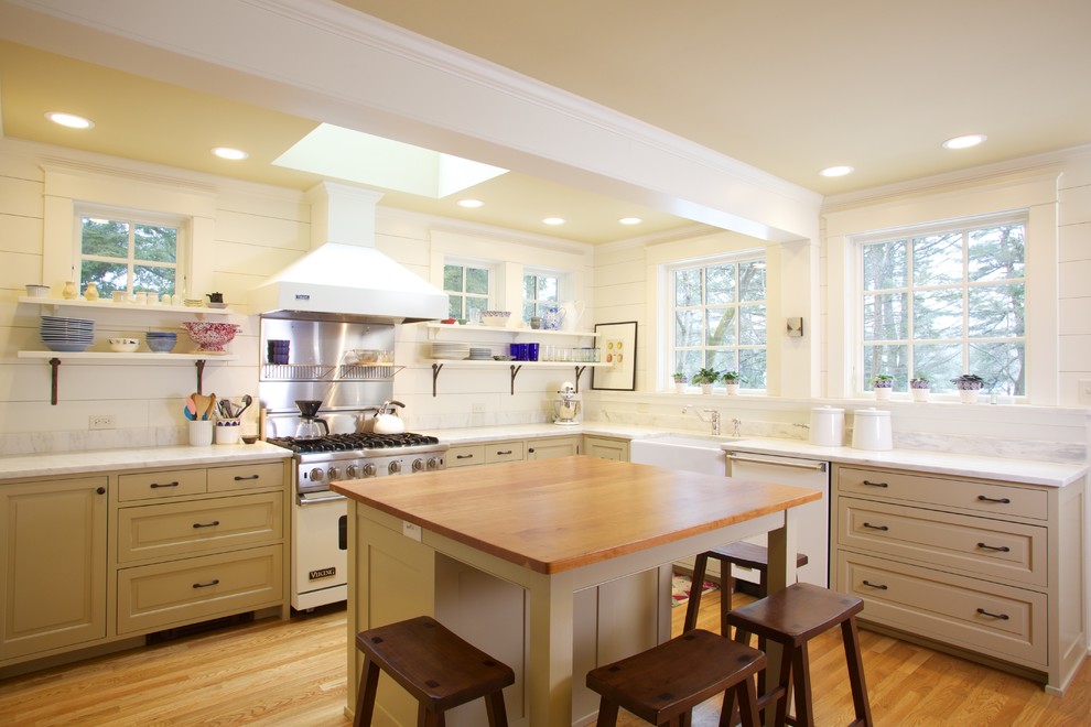 Esempio di una cucina a L classica con lavello stile country, ante con bugna sagomata, ante beige, top in legno, paraspruzzi bianco e elettrodomestici bianchi