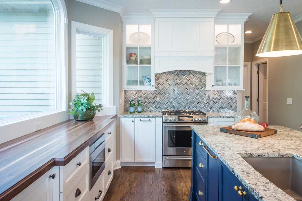 Inspiration for a medium sized traditional kitchen in Cleveland with a submerged sink, shaker cabinets, white cabinets, granite worktops, blue splashback, mosaic tiled splashback, stainless steel appliances, medium hardwood flooring, an island and brown floors.